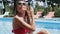 Woman dries her hair near the swimming pool