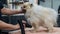 A woman dries a Pomeranian with a hair dryer after washing in a grooming salon.