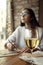 Woman drink white wine near window in restaurant