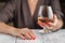 Woman drinking alcohol on dark background. Focus on wine glass