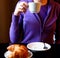 Woman drinking cappuccino at breakfast close-up