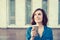 Woman drinking coffee outdoors holding paper cup