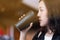 A woman drinking coffee by reuse black coffee bottle in coffee cafe