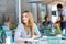 Woman drinking coffee and writing notes in cafe