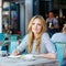 Woman drinking coffee and writing notes in cafe