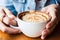 Woman drinking a cup of cappucino coffee