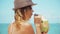 Woman drinking fresh coconut water with straw on beach fun vacation. Closeup of woman holding young green tropical fruit sipping f