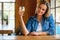 A woman drinking fresh craft cider from the tap, holding up her glass to cheers her friends at the bar