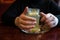 Woman drinking hot and refreshing ginger tea with slice of lemon in a restaurant. Hands holding cup of natural herbal tea on