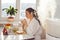 Woman drinking tea reading tablet at humidifier