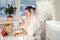 Woman drinking tea reading tablet at humidifier