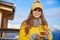 Woman drinking warm tea in the rustick wooden terrace on mountain, alpine view, snow on hills