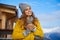 Woman drinking warm tea in the rustick wooden terrace on mountain, alpine view, snow on hills