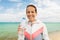 Woman drinking water after exercising on beach