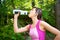 Woman Drinking Water after a Workout Outdoors