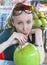 Woman drinks coconut milk from a big green coco