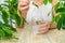 Woman dripping chlorophyll supplement into a glass of water. Selective focus.