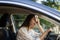 Woman driver being hot during heat wave in car, suffering from hot weather wipes sweat from forehead