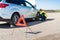 Woman driver changing damaged wheel on roadside