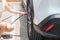 Woman driver hand inflating tires of vehicle, checking air pressure and filling air on car wheel at gas station. self service,
