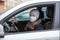 A woman driver puts on a medical mask during a pandemic, protection from the virus