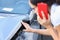 Woman driver is talking on smartphone and examines damage to car after accident closeup