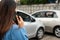 Woman drivers call insurance after a car accident before taking pictures and sending insurance. Online car accident insurance