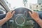 Woman driving through the city streets, close up shot of female hands on steering wheel