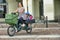 Woman driving electric cargo bike transporting her two kids Delberate motion blur