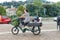 Woman driving electric cargo bike transporting her two kids Delberate motion blur