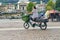 Woman driving electric cargo bike transporting her two kids Delberate motion blur