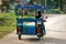 Woman driving shuttle tricycle motorcycle taxi on street in Koh