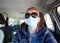 woman driving wearing medical mask - coronavirus protection