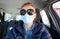 woman driving wearing medical mask - coronavirus protection