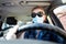 woman driving wearing medical mask - coronavirus protection