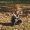 Woman drop leaves in autumn park