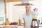 Woman dropping strawberry into the blender