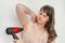 Woman is drying her sweating armpit with hair dryer