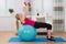 Woman With Dumbbell While Exercising On Fitness Ball