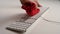 A woman dusting a white keyboard on a white work table.