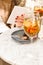 Woman with e-reader in a cafe with blooming flower tea served in a wine glass and futuristic cake