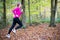 Woman On Early Morning Autumn Run Through Woodland Keeping Fit Through Exercise