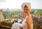 Woman in early morning having breakfast on balcony overlooking city