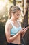 Woman with earphones, phone and fitness with music outdoor, listening for motivation on run in park. Female runner with