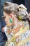 Woman with earring in shape of green elephant and brown, golden and yellow kimono before Gucci