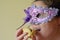 Woman eat Hamantaschen cookie and wearing Purim Mask