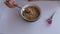 Woman eating Ashura aka Turkish Noah`s Pudding served with bowl and spoon.