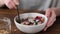 Woman eating breakfast cereals Granola with berries and almond milk