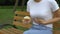 Woman eating burger in park, feeling nausea, food poisoning symptom, gastritis