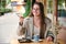 Woman eating a cake and drinking coffee in a cafe.